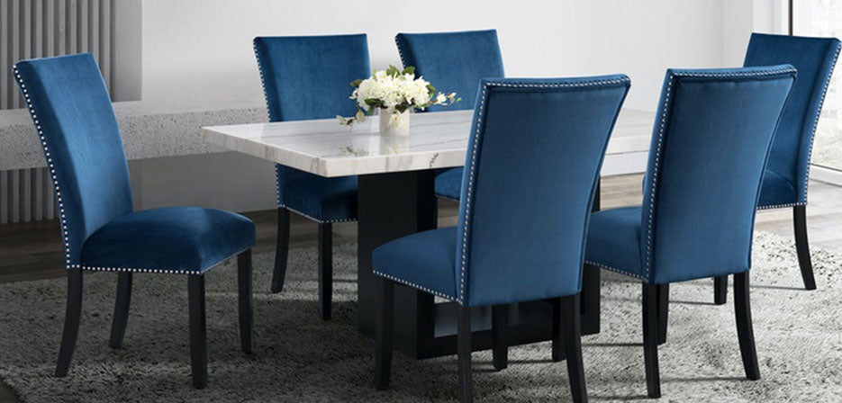 White marble table with velvet blue chairs featuring a nailhead trim