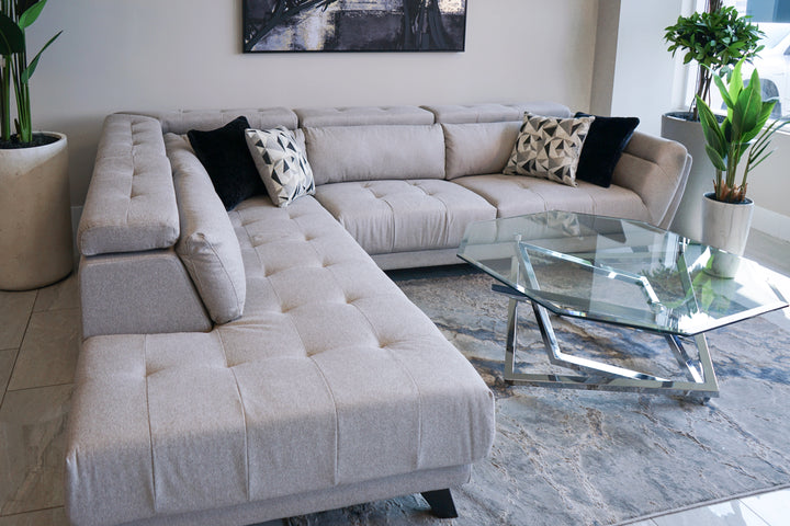 Modern sectional with angled wooden legs. button tuft on the seat cushions and headrest. Angled arm with lumbar pillows. Shown in a cement grey